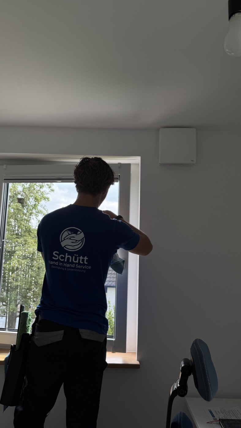 Mitarbeiter von Schütt Hand in Hand reinigt ein Fenster im Wohnraum eines Einfamilienhauses